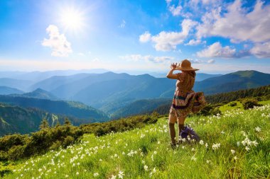 Dağlarda çimenlikte elbiseli hippi kız manzara.