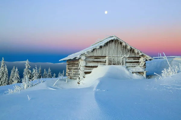 Casitas solitarias escondidas del ojo humano están entre los picos cubiertos de nieve lejos en las montañas en un hermoso día de invierno encantador . — Foto de Stock