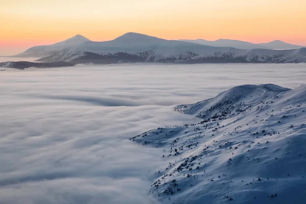 Fantastic sunrise illuminates the Chornohora mountain ridge, thick fog and horizon on a cold winter morning. Beautiful landscape. Wallpaper snowy background. Location place Carpathian, Ukraine, Europe — ストック写真