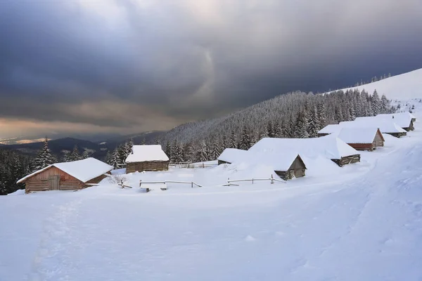 Majestic winter scenery. Dramatic sky. Old wooden huts on the lawn covered with snow. Landscape of high mountains and forests. Wallpaper background. Location place Carpathian, Ukraine, Europe. — 스톡 사진