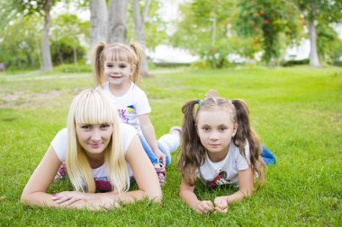 genç anne ve iki kızı otların arasında oynuyor