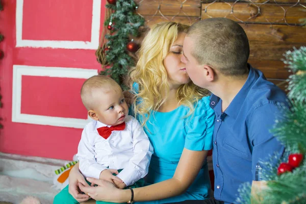 幸福的年轻家庭，在圣诞节的早晨，小男孩吃棒棒糖的肖像. — 图库照片
