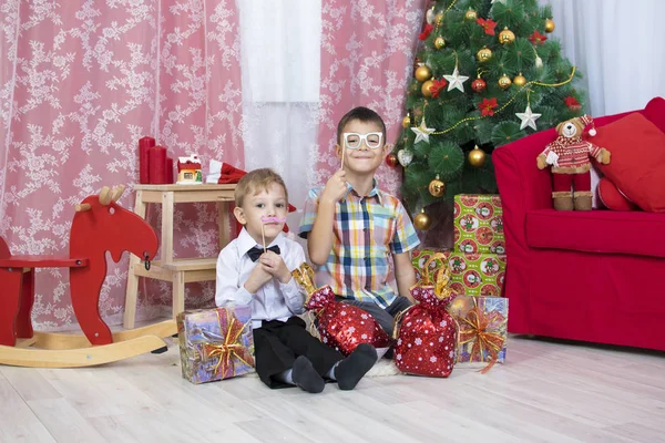 Portrait de garçon mignon avec boîte cadeau embrassant son frère à la maison Image En Vente