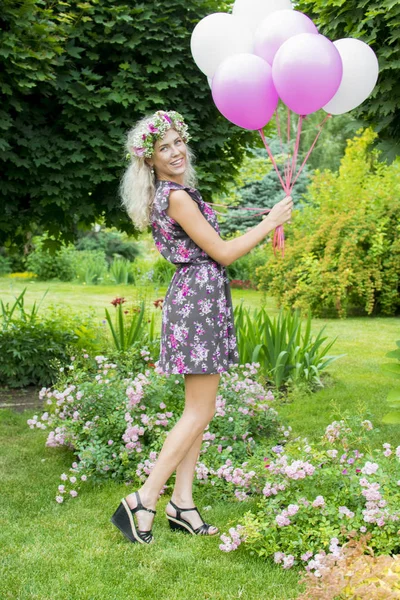 Wszystkiego najlepszego kobieta na tle nieba z tęczowe balony powietrza w rękach. słonecznie i pozytywna energia natury. Młoda piękna dziewczyna na trawie w parku. — Zdjęcie stockowe