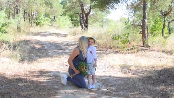 Pregnant mother and son walking through the woods — Stock Video