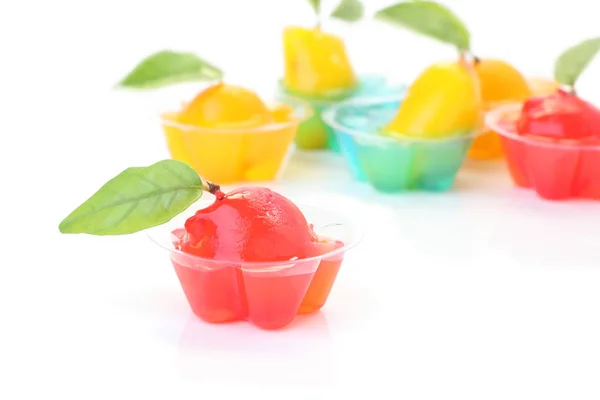 Frutas rojas de imitación en taza de gelatina en piso blanco . — Foto de Stock