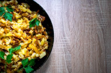 Ahşap arka plan üzerinde tavada mantar patates kızartması.