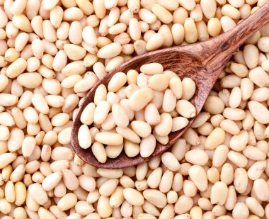 Ahşap kaşıkta çam fıstığı, arka plan. Yukarıdan görünüşü