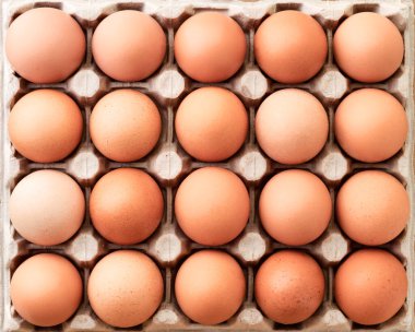 Kutu tepside bir sürü taze kahverengi yumurta var. Arkaplan