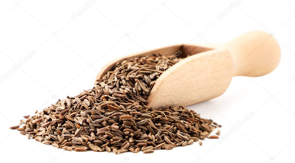 Cumin seeds in a wooden spoon close-up on a white background. Isolated