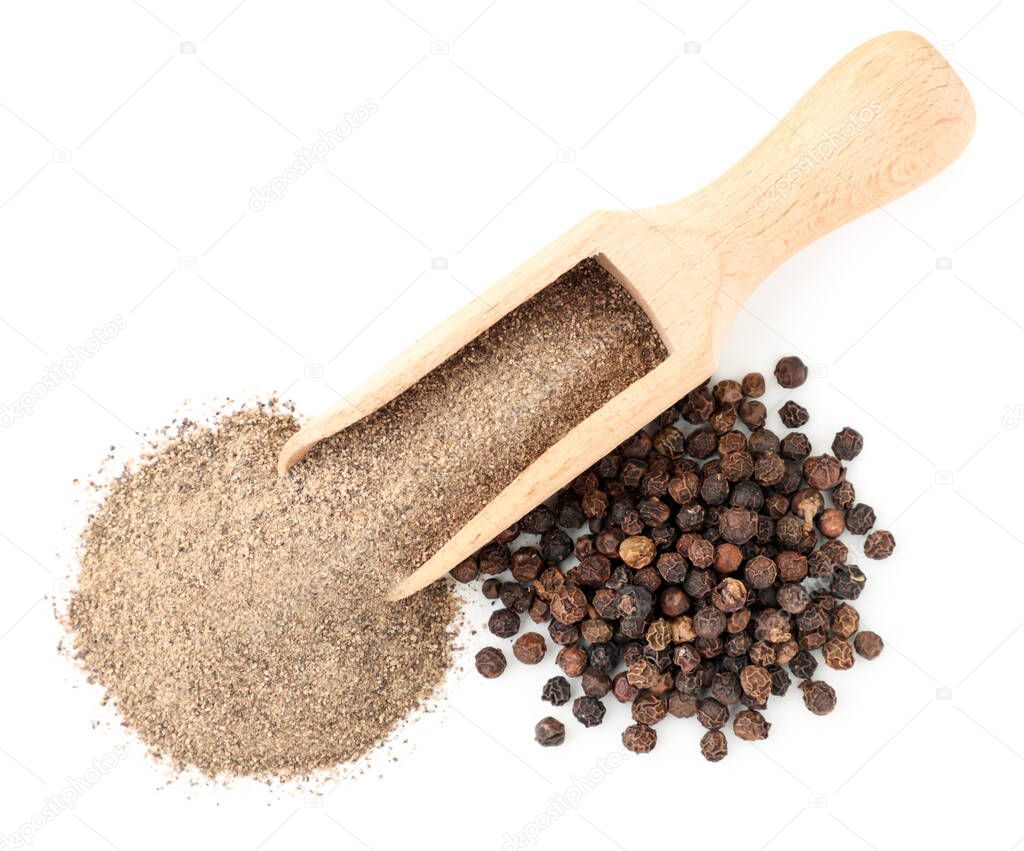 Ground black pepper in a spoon and pepper peas close-up on a white background isolated. The view from top