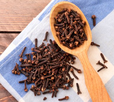 Ahşap arka planda kaşık içindeki karanfil kokusu