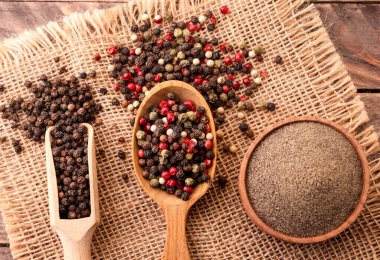 Karabiber, ahşap bir arka planda kaşık içinde karabiber ve biber karışımı. Yukarıdan görünüm