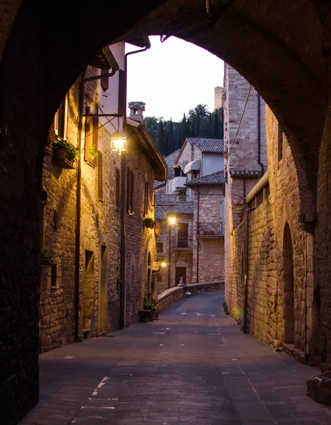 Een middeleeuwse schilderachtige straat in Assisi 's nachts, uitzicht door een — Stockfoto
