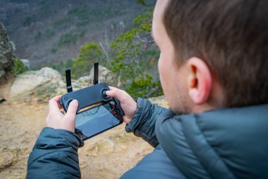 İnsansız uçak kumandası tutan adam..