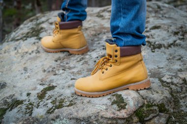 Uçurumda çalışan bir çift sarı çizme.