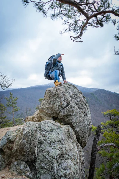 Путешественник взбирается на вершину скалы и смотрит вдаль, пеший туризм, концепция путешествия . — стоковое фото