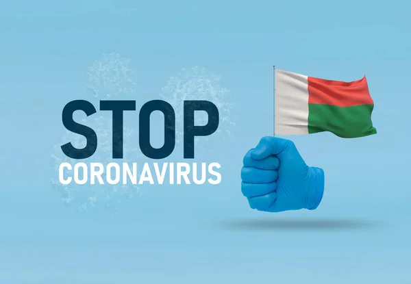 COVID-19 Visual concept - hand-text Stop Coronavirus, hand-gesture versus virus infection, clenched fist holds flag of Madagascar. Pandemic 3D illustration. — Stock Photo, Image