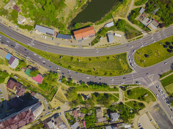 Aerial view at junctions of city highway. Vehicles drive on roads.