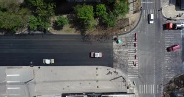 İnşaatın asfaltlanmasının havadan aşağı görüntüsü ticari tamir ekipmanları yol sıkıştırma makinesiyle çalışıyor. Yeni ve eski yol yüzeyi arasındaki karşıtlık.
