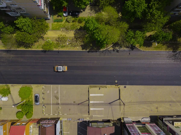 Bovenaanzicht vanuit de lucht van het asfalt bouwwerkzaamheden met commerciële reparatie apparatuur weg roller compactor machine. Contrast tussen nieuw en oud wegdek. — Stockfoto