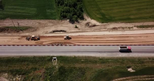 Väg byggarbetsplats med maskiner, bulldozer, utgrävning uppifrån. 4K-video, flygvy. — Stockvideo