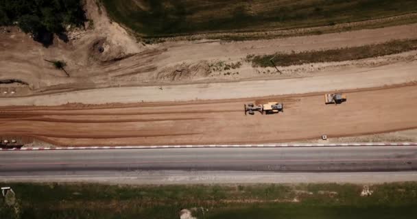 Construcción de carreteras Sitio cerca de la carretera con maquinaria, excavadora, excavación desde arriba. 4K de vídeo, vista de arriba hacia abajo . — Vídeos de Stock