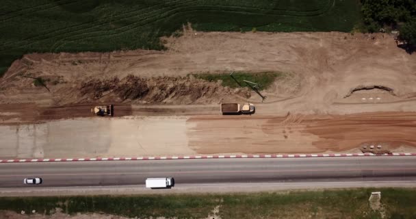 Construcción de carreteras Sitio cerca de la carretera con maquinaria, excavadora, excavación desde arriba. 4K de vídeo, vista de arriba hacia abajo . — Vídeos de Stock