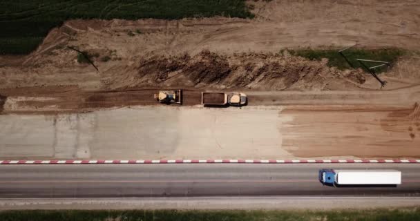 Estrada Área de Construção perto da estrada com máquinas, escavadeira, escavação de cima. Vídeo 4K, vista de cima para baixo . — Vídeo de Stock