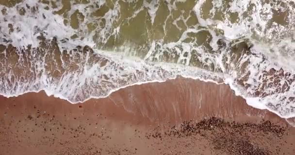 Vue du haut vers le bas des vagues se brisant dans le sable, survolant la plage de sable tropical et les vagues 