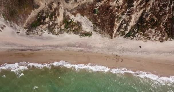Сверху вниз вид волн, разбивающихся в песке, пролетающих над тропическим песчаным пляжем и волнами — стоковое видео