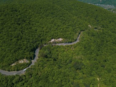 Dağ kıvrımlı zig zag yolu. Üst hava manzarası: Arabalar yukarıdan yola çıkıyor.