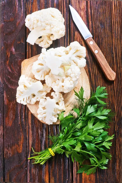 Cauliflower with knife and greens — Stock Photo, Image