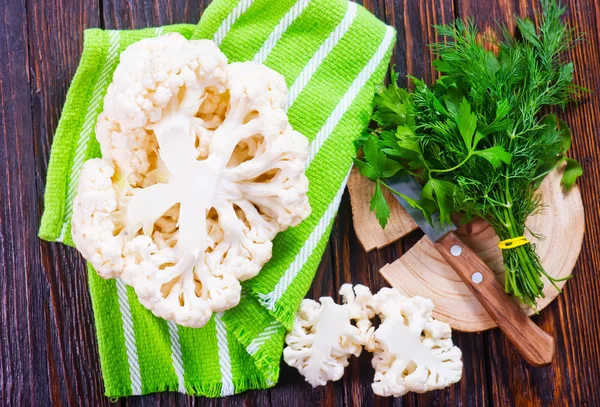 Cauliflower with knife and greens — Stock Photo, Image