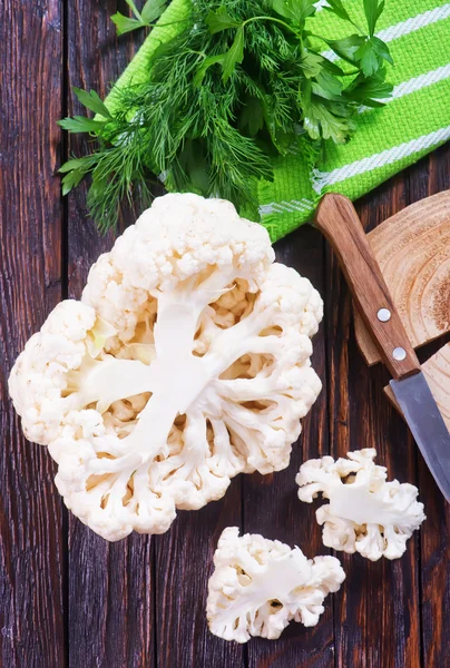 Cauliflower with knife and greens — Stock Photo, Image