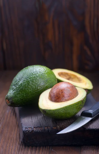 Fresh avocados on wooden board — Stock Photo, Image