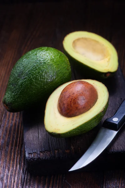 Fresh avocados on wooden board — Stock Photo, Image