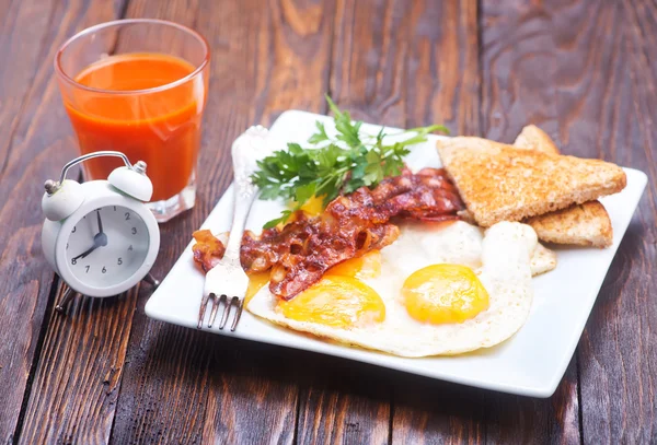 Fried bacon and eggs on plate — Stock Photo, Image