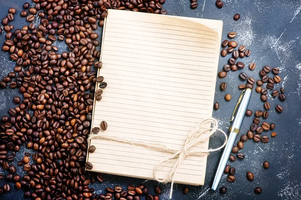 Coffee beans and notebook — Stock Photo, Image