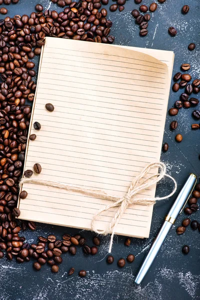 Granos de café y cuaderno — Foto de Stock