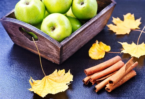 Green apples and cinnamon sticks — Stock Photo, Image