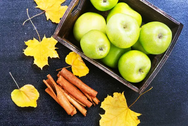 Green apples and cinnamon sticks — Stock Photo, Image