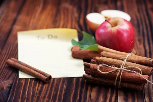 Jablka se skořicí na dřevěný stůl — Stock fotografie