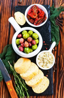 zeytin, peynir ve ahşap masa üzerinde kuru domates