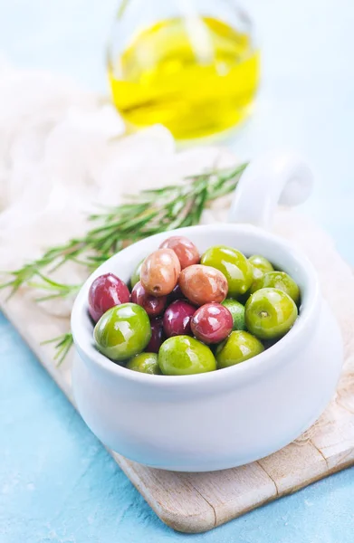 Olivy v misce a na stůl — Stock fotografie