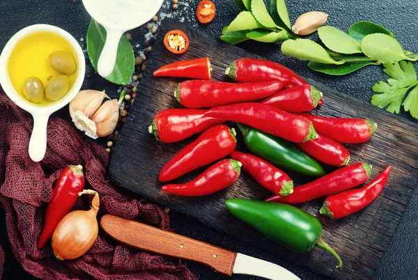 Aroma spices on a table, chilli peppers and aroma oil — Stock Photo, Image