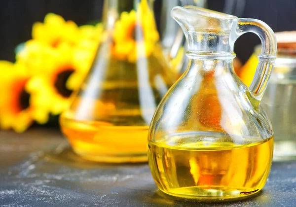 Oil in bottles on table — Stock Photo, Image