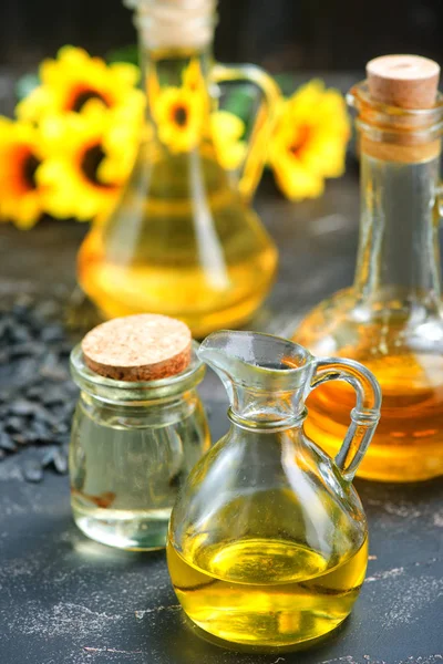 Oil in bottles on table — Stock Photo, Image