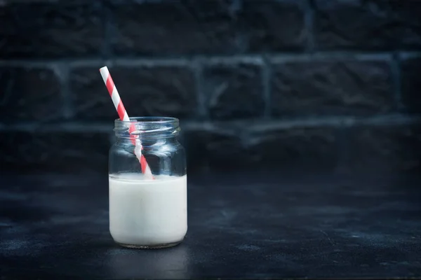 Mléko ve skle se slámou — Stock fotografie