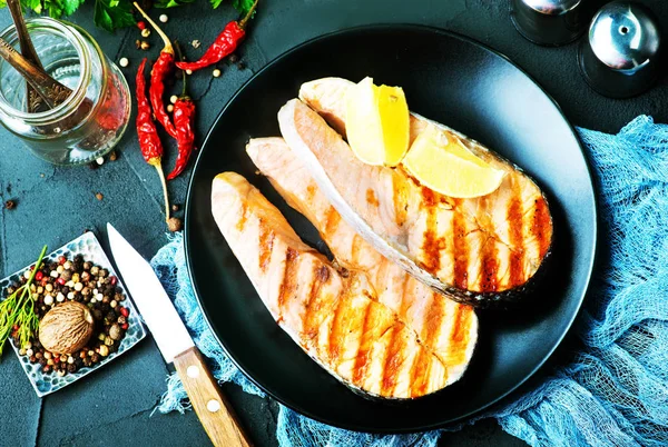 Peixe frito em prato preto — Fotografia de Stock